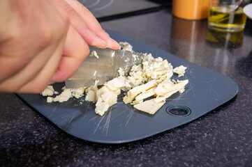 Culinary Art: Dicing the Exquisite Blue Cheese for the Recipe.