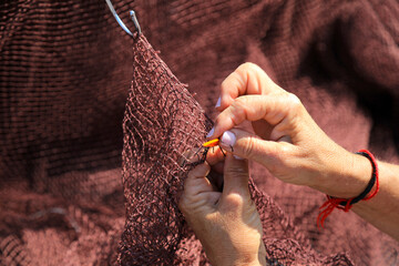 manos de mujer cosiendo redes de pesca en el puerto redera en getaria país vasco 4M0A8523-as23 - obrazy, fototapety, plakaty