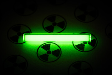 Tritium. Radioactive glow. Gaseous tritium light source in a glass vial. Radiation sign. Neon green glow hazards to employees, inspectors. Irradiated zone. Luminous fluorescence, phosphorescence  - obrazy, fototapety, plakaty