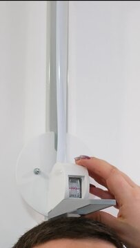 in the clinic with a professional stadiometer, the doctor measures the height of a dark-voiced man unrecognizable people measure the height of a persons height close-up space for text 