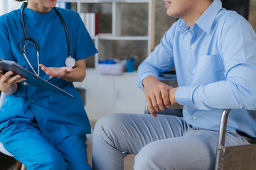 Obraz premium Doctor and patient sitting and talking at medical examination at hospital office, close-up. Therapist filling up medication history records. Medicine and healthcare concept.