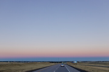 Empty highway at sunset. Beautiful sky in orange and purple tones at dusk