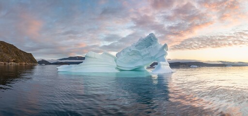 Arctic nature landscape with icebergs in Greenland icefjord with midnight sun. Early morning summer...