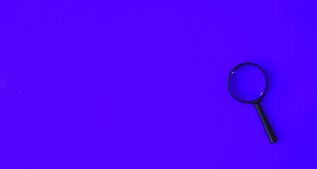 Magnifying glass in a black frame on a blue background.  Concept research, objects magnification.  Flat top view.  Space for copying text, magnifying glass in black.
