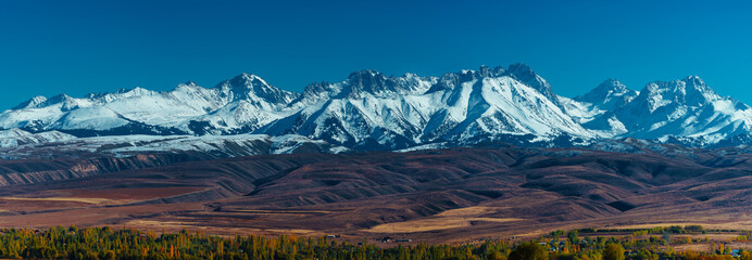 Picturesque panorama with snowy high mountains in autumn - obrazy, fototapety, plakaty