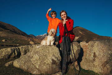 Happy mother and son with shih tzu dog portrait in the mountains