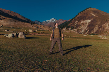 Fototapeta premium Happy young man tourist in the mountains in autumn