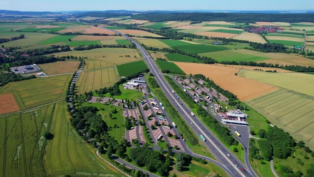 Aerial flyover above the Autobahn highway and truck stop rest area during summer in Germany