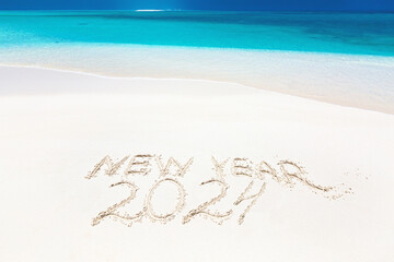 Inscription word NEW YEAR and numbers 2024 on sandy beach