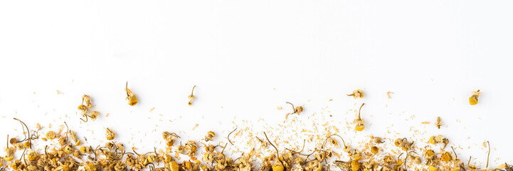 Dried camomile flowers on white table with copyspace