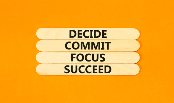 Decide commit focus succeed symbol. Concept word Decide Commit Focus Succeed on beautiful wooden stick. Beautiful orange background. Business decide commit focus succeed concept. Copy space.