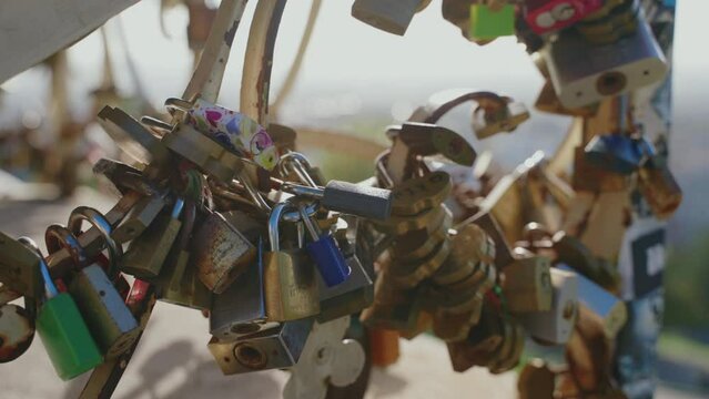 muchos candados de colores y formas diferentes enganchados en una barandilla 