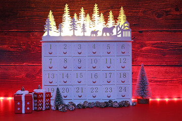 a Christmas advent calendar Lit by red fairy lights.