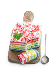Multicolored rainbow cake decorated with colored marshmallow isolated on white