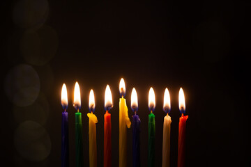 Closeup of Hanukkah menorah, or hanukkiah for Jewish holiday Hanukkah. Nine colored candles....