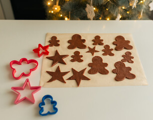 Cut out shapes from Christmas cookie dough lie on parchment paper