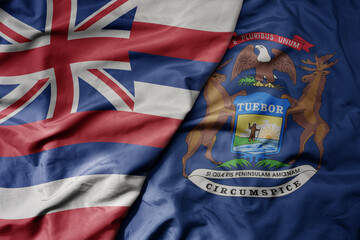 Fototapeta premium big waving colorful national flag of michigan state and flag of hawaii state .