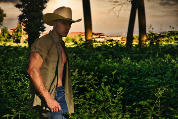 A man wearing a cowboy hat standing in a field