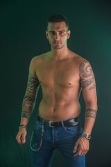 A shirtless man with a tattoo on his arm