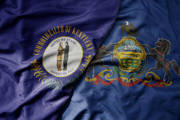 big waving colorful national flag of pennsylvania state and flag of kentucky state .