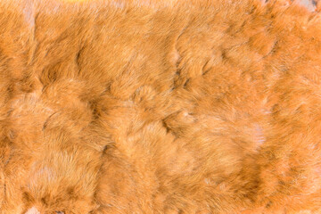 Close-up of a texture photograph illustrating the tactile feel of a red fox fur fabric featuring a soft, velvety surface meticulously crafted from long tightly woven pile.