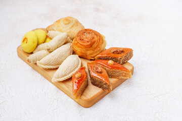 Traditional Azerbaijan holiday Novruz background with green semeni,traditional azerbaijan sweets,shekerbura,qogal,paxlava,mutaki and different nuts and sweets,top view,space for copy