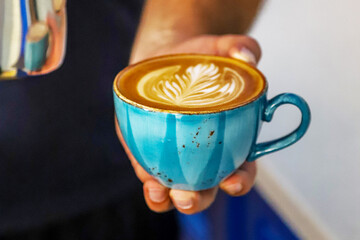 Cup with hot cappuccino with foam on the table. coffee art.