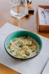 Tasty Mussels in cheese sauce with dumplings served with greens. Restaurant menu