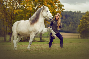 A young woman and her icelandic horse working and cuddle together, equestrian natural horsemanship...