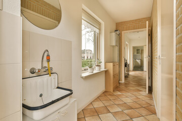 a bathroom with tile flooring and white fixtures on the wall behind it is a sink, mirror and window