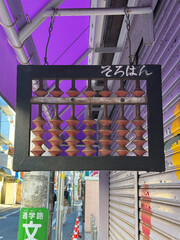 Abacus sign hanging from the eave of a store