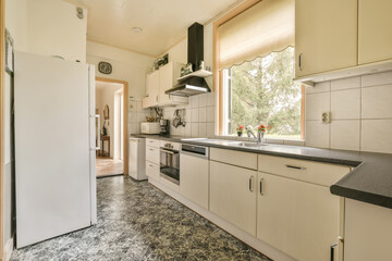Fototapeta na wymiar a kitchen area with white cabinets and black counter tops on the floor in front of the refrigerator door is open