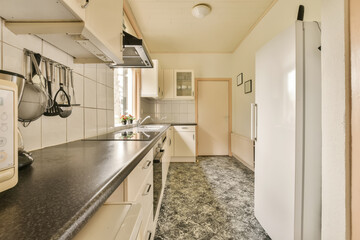 a kitchen area with white cabinets and black counter tops on the counters in this photo is taken from the inside