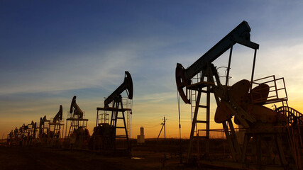 Fototapeta na wymiar Working oil pumps silhouette against sunset