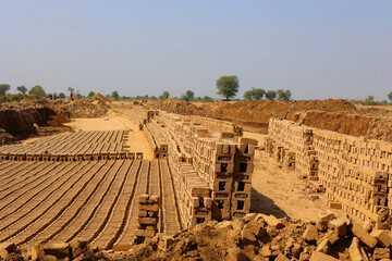 Raw brick laid out in stacks for drying. Bricks in a brick factory. Traditional production of clay bricks in India.