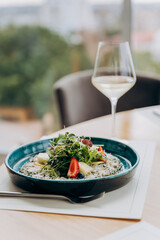 Beef carpaccio with pesto sauce and parmigiano cheese decorated by salad and fruit. Restaurant menu