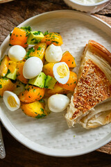 Breakfast. Turkish puff pastry, salad of yellow tomatoes, avocado, quail eggs. White sauce