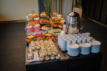 Black buffet table with beautiful decorated dishes. Breakfast at hotel. Catering. Decoration for a Banquet