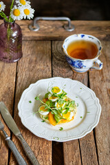 Potato cutlet with yellow tomatoes, peas, cheese and quail eggs.