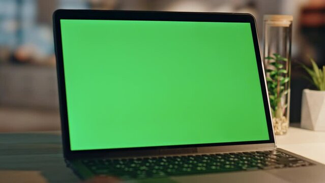 Freelancer finger touching chromakey laptop touchpad at night office closeup