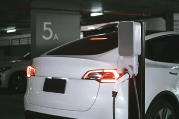 EV electric car recharge at shopping center parking lot charging in downtown city showing urban...