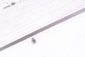 overhead aerial view with drone of a road in a snowy countryside