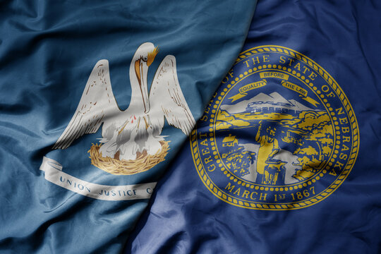 big waving colorful national flag of nebraska state and flag of louisiana state .