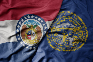 big waving colorful national flag of nebraska state and flag of missouri state .