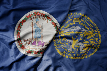 big waving colorful national flag of nebraska state and flag of virginia state .