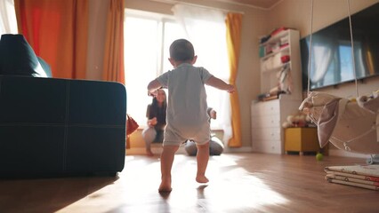 baby runs to his parents for first steps. happy family child - dream concept. a little son takes his first steps towards his family at the window of the house. Cute baby learning to lifestyle walk