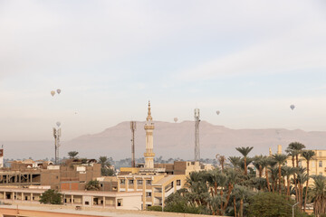 minaret skyline in village in Luxor, Egypt with mountains in the background