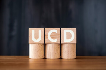 There is wood cube with the word UCD. It is an abbreviation for User Centered Design as...