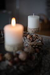 Close-up of two candles in a candlestick with ornaments on an Advent wreath