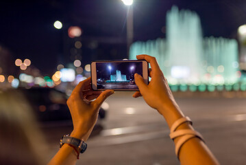 Young woman takes photos using smart mobile